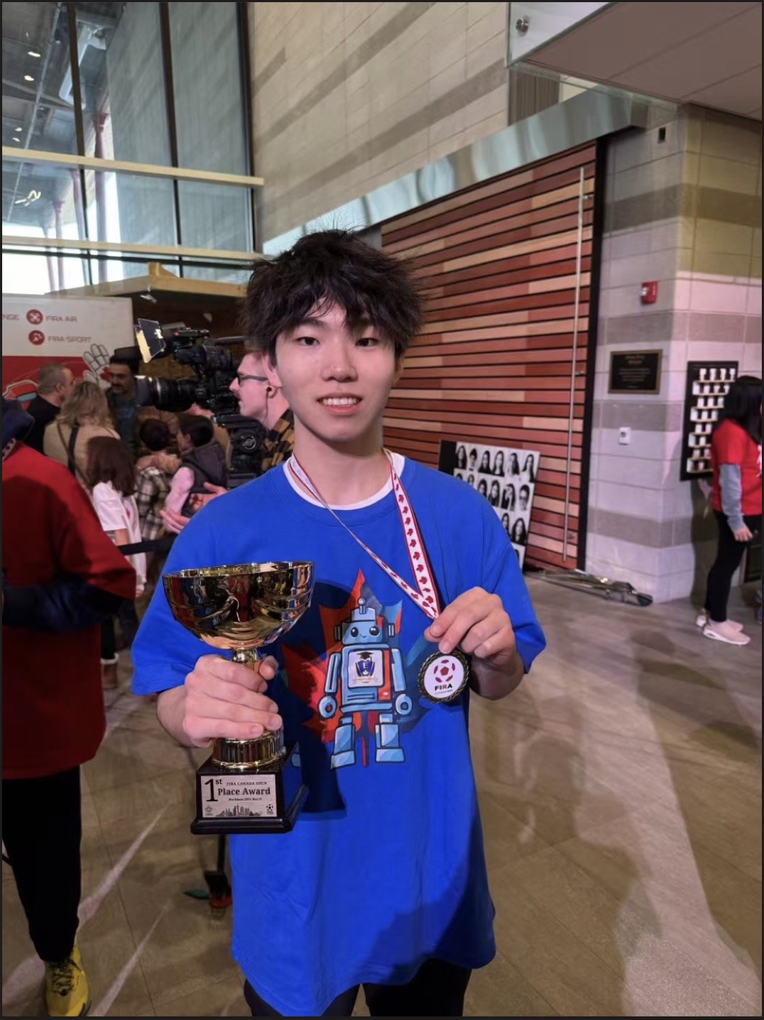 Shawn holding his first place trophy and medal at the 2025 FIRA Canada Open robotics competition